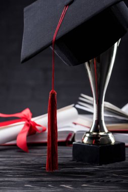 Mezuniyet Kupası kitaplar ve diploma önünde kupa bardak