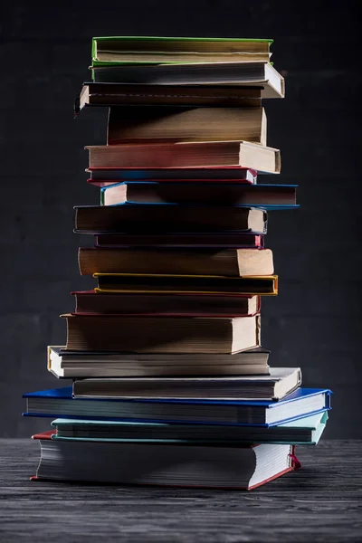 Hoher Bücherstapel Auf Dunklem Holzgrund — Stockfoto