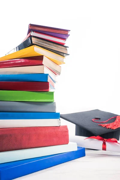 Chapéu Graduação Diploma Com Fita Vermelha Por Livros Mesa — Fotografia de Stock Grátis