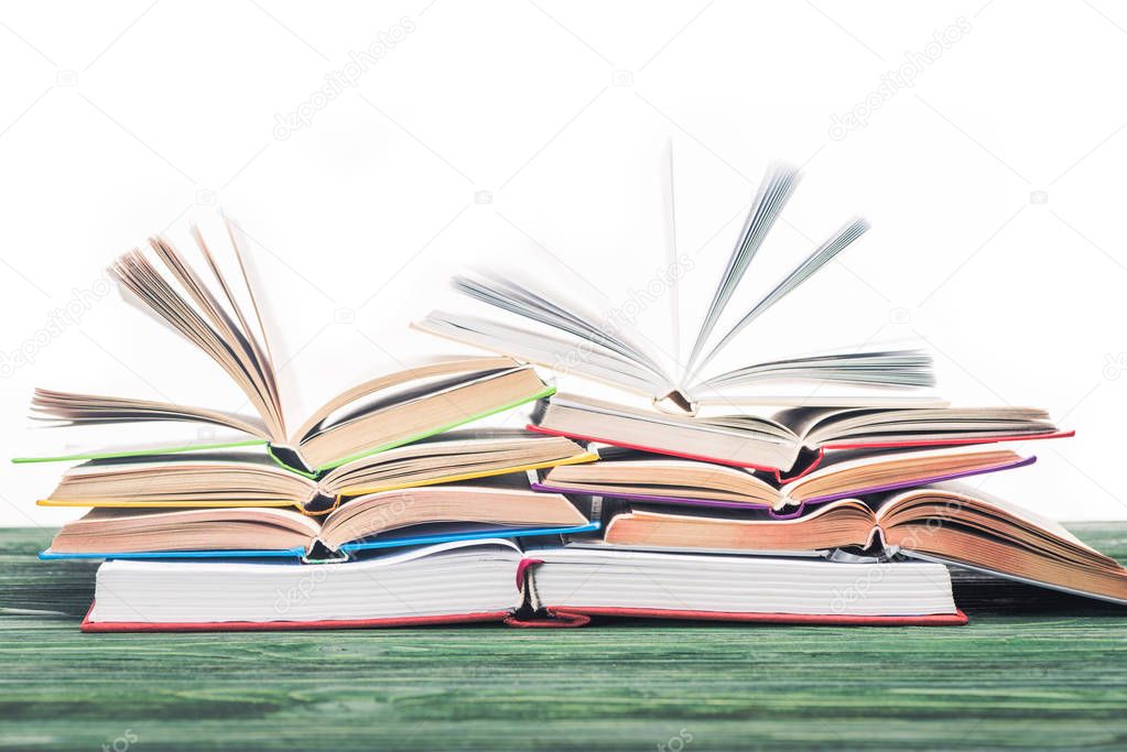 Open books stacked on wooden table