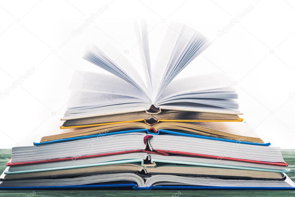 Stack of open books on wooden table