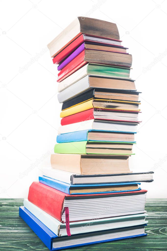 Bent tower of stacked books on white background