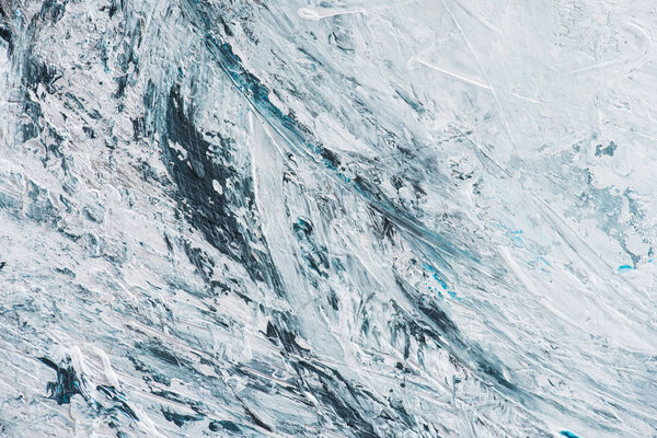 Close up of light blue and white brush strokes of oil paint
