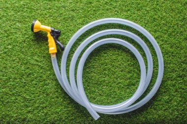 top view of hosepipe on green grass, minimalistic conception  clipart