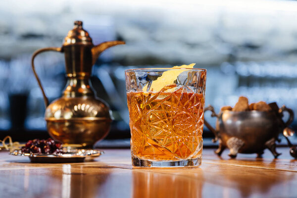 close-up view of glass with old fashioned cocktail on table