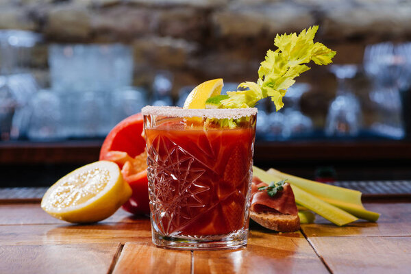 bloody mary cocktail in glass on wooden table