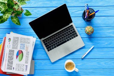 Laptop ve iş grafik mavi ahşap masa üzerinde açma