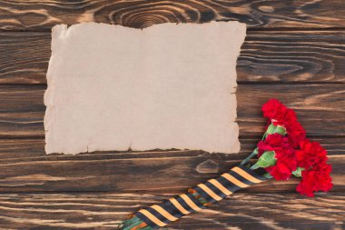 top view of empty old paper and carnations wrapped by st. george ribbon  clipart