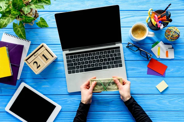 Hände Mit Geld Laptop Auf Blauem Holztisch Mit Schreibwaren — Stockfoto