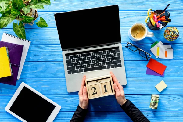 Geschäftsmann Hält Kalender Laptop Auf Blauem Holztisch Mit Schreibwaren — Stockfoto