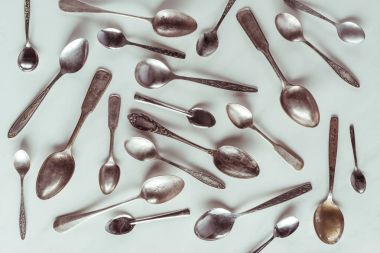Vintage metal spoons on white background clipart