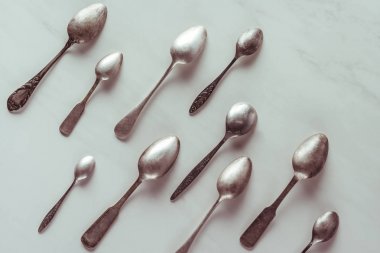 Various vintage spoons on white table clipart