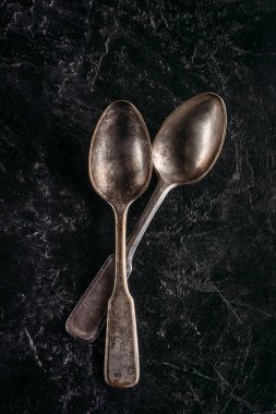 Eskimiş metal kaşıklar koyu arkaplanda
