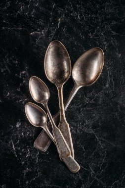 Set of vintage spoons on dark table clipart