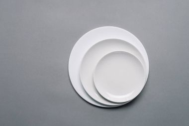Картина, постер, плакат, фотообои "белые тарелки разных размеров на сером фоне
", артикул 191429556