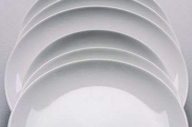white plates in a row on white table clipart