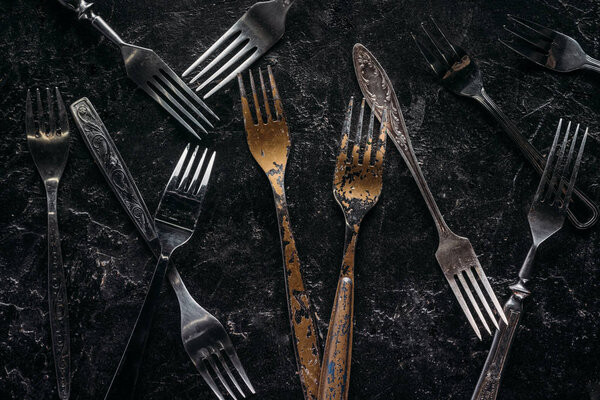 Старые металлические вилки на ржавом фоне
