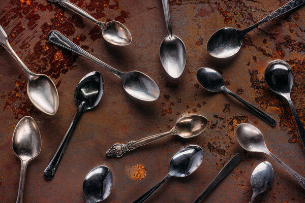 Vintage metal spoons on rusted background