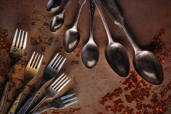 Vintage spoons and forks on rusted table