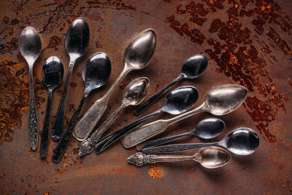 Various vintage spoons on rusted table