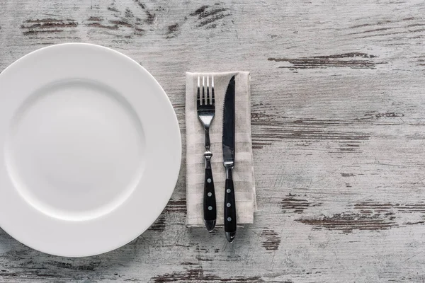 Άσπρο Πιάτο Και Πιρούνι Μαχαίρι Χαρτοπετσέτας Ξύλινο Τραπέζι — Φωτογραφία Αρχείου