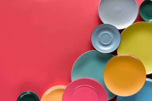Composition of colorful plates on red background