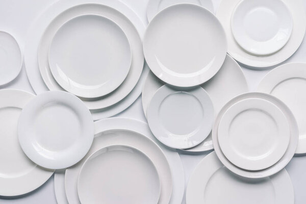 white plates composition on white background