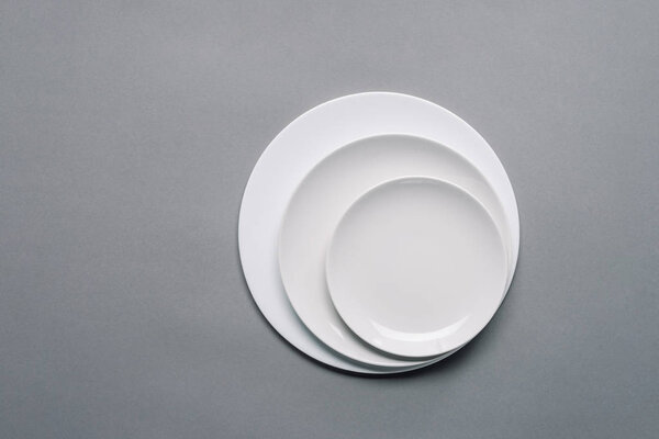 White plates of different sizes on grey background
