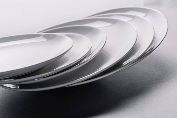 White ceramic plates stacked on white table
