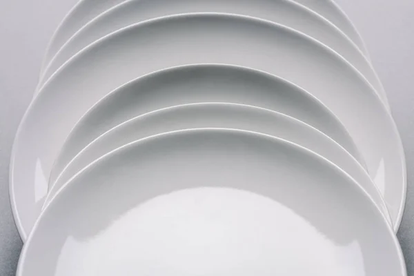 Белые Тарелки Ряд Белом Столе — стоковое фото