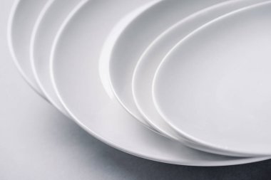 Beyaz arka plan üzerinde yığılmış beyaz seramik plakalar