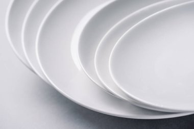 White ceramic plates stacked on white background clipart