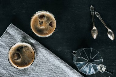 kahve makinesi, soğuk bardak ile düz yatıyordu buzlu kahve ve siyah masa üstünde kaşık