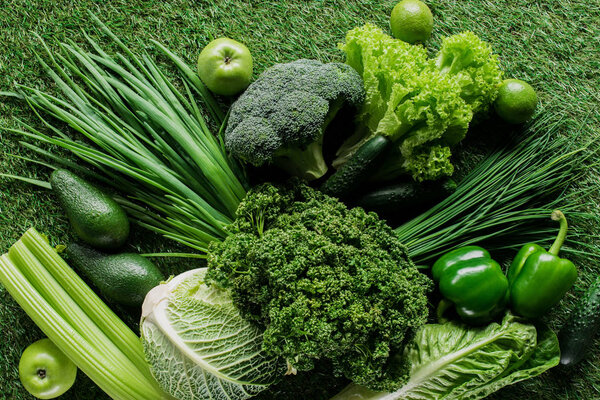 top view of uncooked tasty green vegetables on grass, healthy eating concept