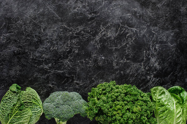 top view of broccoli, savoy cabbage and parsley on concrete table, healthy eating concept