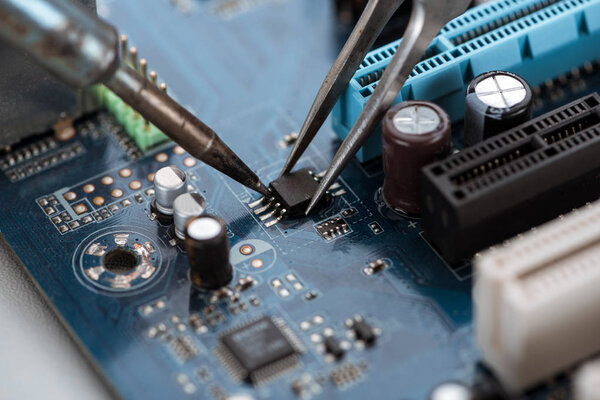 Soldering typical desktop computer baseboard close-up view