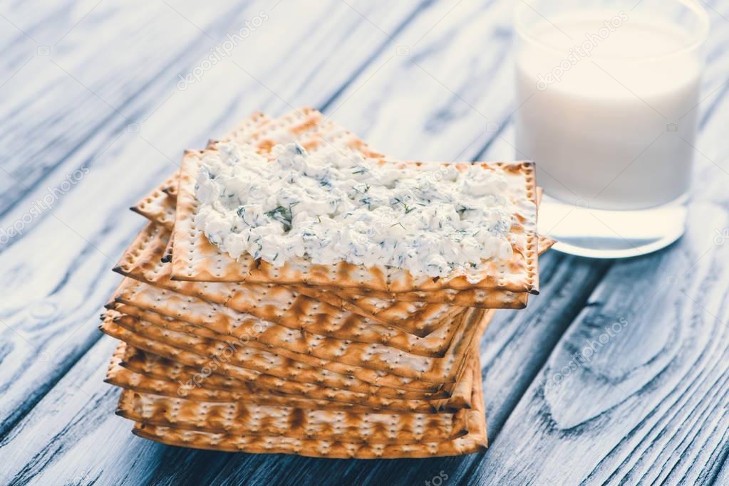 close-up view of crispy crackers with cottage cheese and glass of milk on wooden table 