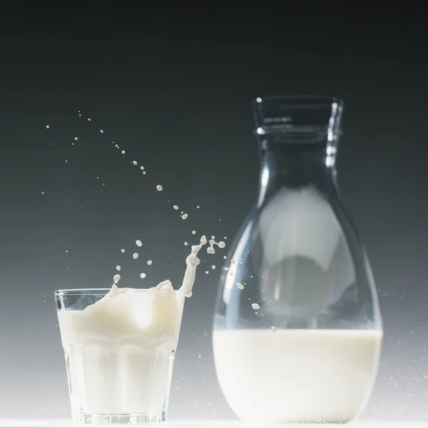 Стакан Молока Брызгами Перед Бутылкой Молока — стоковое фото