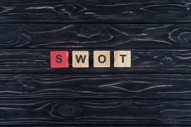 ahşap bloklar koyu ahşap masa üzerinde yapılmış kelime swot Üstten Görünüm