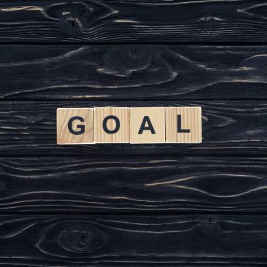 top view of word goal made of wooden blocks on dark wooden tabletop clipart