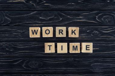 top view of work time words made of wooden blocks on dark wooden tabletop clipart
