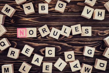 top view of no rules lettering made of wooden cubes on brown wooden tabletop clipart