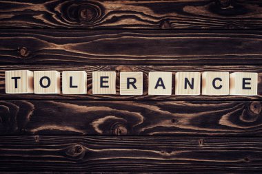 düz lay ile kahverengi ahşap yüzey üzerinde tolerans Word'de düzenlenmiş ahşap bloklar