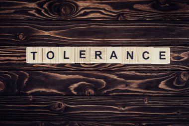 düz lay ile kahverengi ahşap yüzey üzerinde tolerans Word'de düzenlenmiş ahşap bloklar