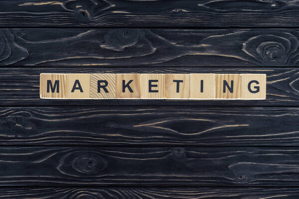 top view of word marketing made of wooden blocks on dark wooden tabletop