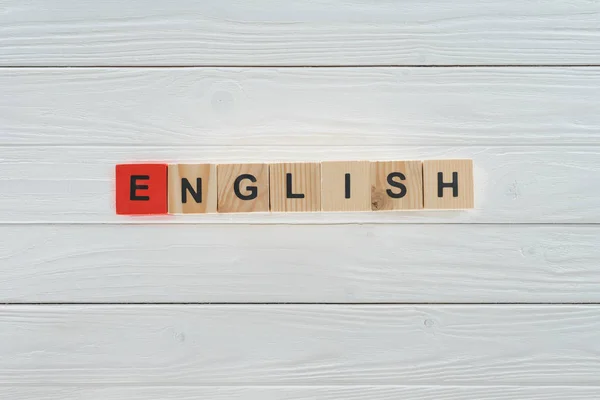 在白色木桌上用木制立方体制作的英语单词的顶部视图 — 图库照片