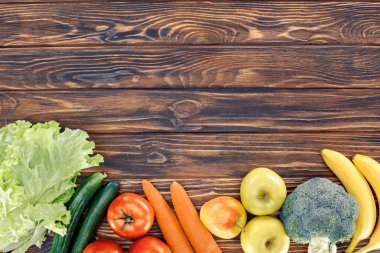 top view of fresh healthy fruits and vegetables on wooden table clipart