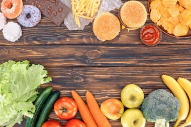 top view of fresh fruits with vegetables and assorted unhealthy food on wooden table  clipart