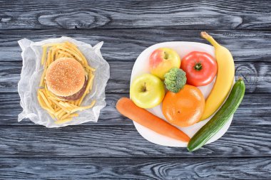 ahşap masa üzerinde hamburger patates kızartması ile ve taze meyve sebze ile Üstten Görünüm 