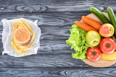 ahşap masa üzerinde hamburger patates kızartması ile ve taze meyve sebze ile Üstten Görünüm 